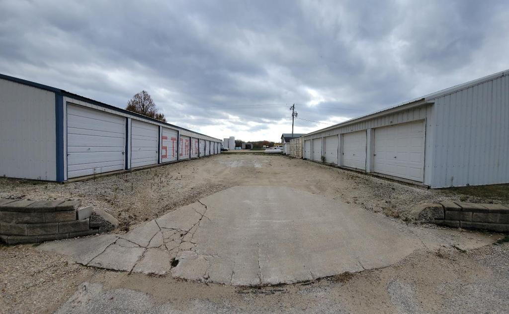 The middle row of Elkader Storage Units. Several garage doors on long buildings with STORAGE painted along the left side doors.